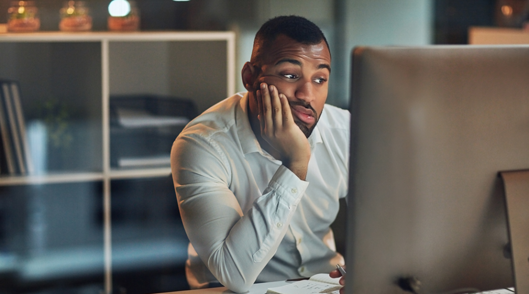 A male worker bored at his computer