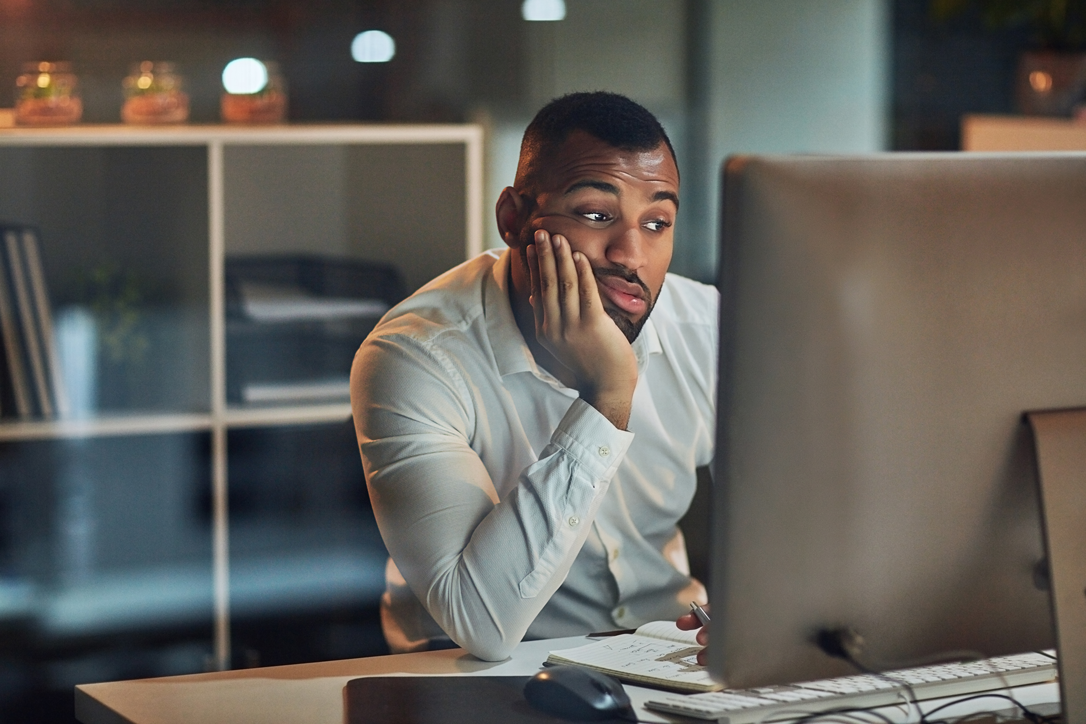 A male worker bored at his computer